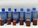 several blue bottles of various sizes and shapes are lined up