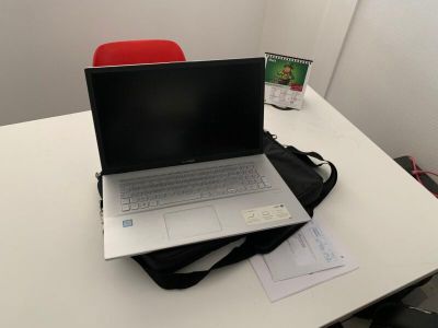 un ordinateur portable posé sur un sac, sur une table
