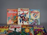 some comics are sitting on a table with a gray background