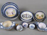 Plusieurs pièces de poterie bleue et blanche sont disposées sur une surface grise