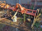 un tracteur qui est garé dans l'herbe près d'un bâtiment