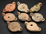six pièces de poterie antique sont exposées sur un fond noir