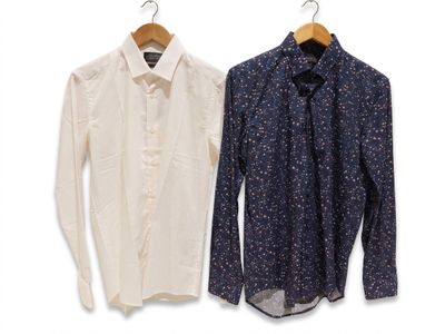 two shirts hanging on a clothes hanger on a white wall