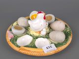 a ceramic figurine of a chicken and eggs on a plate