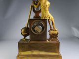 a statue of a man playing a musical instrument on top of a clock