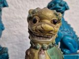 a small statue of a dog sitting on a table with other statues behind it