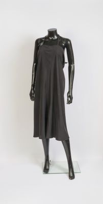 mannequin dressed in a black dress on a glass stand