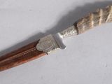 a knife with a horn handle on a white surface