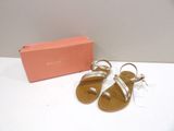 tan and white sandals with a pink box on a white table