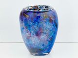 a blue vase that is sitting on a white surface