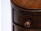 an image of a round wooden table with three drawers