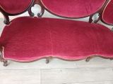 a red couch that is sitting on a wooden floor