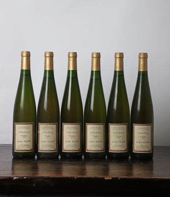 six bouteilles de vin sont alignées sur une table en bois