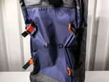 a blue suitcase with a black handle and orange straps