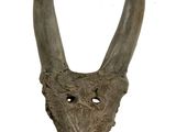 sculpture of a goat ' s head with horns on a wooden base