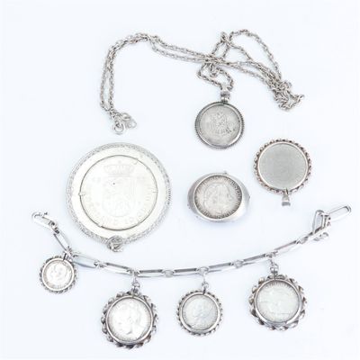 a close up of a group of silver jewelry on a white surface