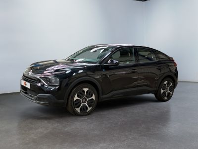 the black suv is parked in a large room with a white wall