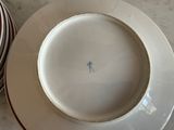 a white plate with a blue stick on it next to a striped bowl