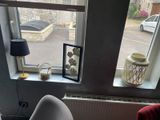une photo d'un vase et une photo d'un chat sur le rebord d'une fenêtre