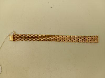 une image d'un bracelet en or sur une surface blanche