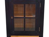 une photo d'un meuble noir avec des portes vitrées et des tiroirs