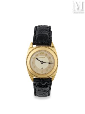 un gros plan d'une montre-bracelet en or avec un bracelet en cuir noir