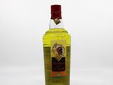 yellow bottle of liquor sitting on a white surface with a white background