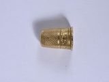 gros plan d'une bague en or sur une surface blanche