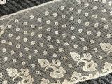 two pieces of white lace on a black surface