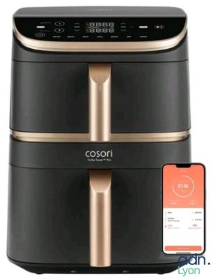 une friteuse à air chaud noire et dorée posée à côté d'un iPhone