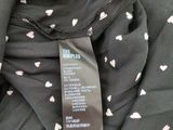 the back of a black and white shirt with hearts on it
