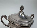 a silver cup with a lid on a table