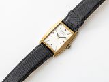 a watch that is sitting on a black leather strap