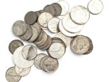 a pile of silver coins on a white surface