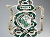 une image représentant une théière verte et blanche ornée d'un motif