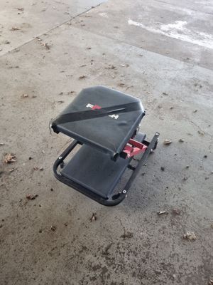 une valise noire posée par terre, munie d'une poignée rouge