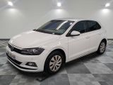the white volkswagen polo is parked in a room with a checkered floor