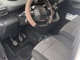 the interior of a small car with a steering wheel and dashboard controls