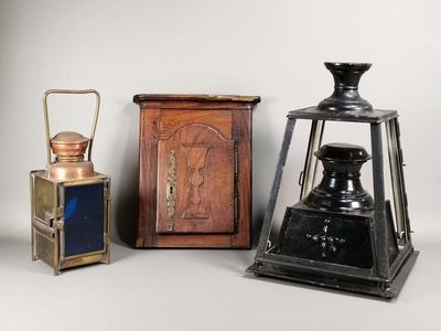 Trois types différents de lanternes anciennes sont exposés sur un support blanc