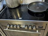 les casseroles et les poêles sont posées sur la plaque de cuisson d'une cuisinière en acier inoxydable