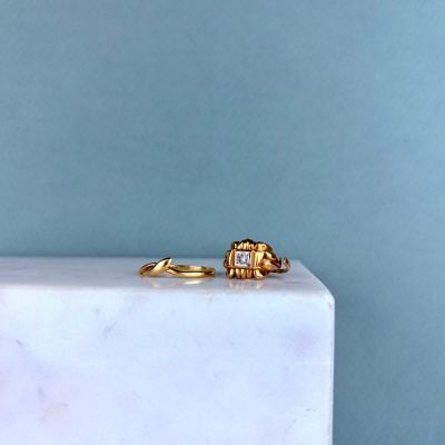 un gros plan sur une paire de bagues en or posées sur un bloc de marbre
