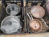 de nombreuses casseroles et poêles dans un panier posé par terre