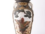 un vase avec un oiseau posé sur une table