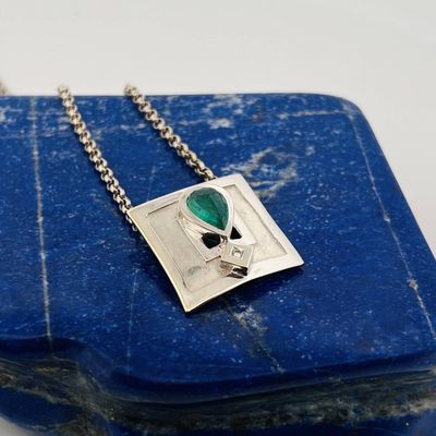 un gros plan d'une pierre bleue sur laquelle est accroché un pendentif en argent