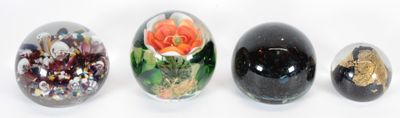 quatre œufs en verre aux motifs variés sont alignés sur une surface blanche