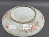 a white bowl with red flowers on it on a table