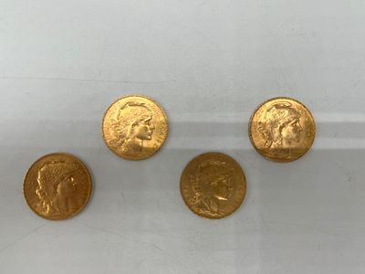 un groupe de quatre pièces d'or posées sur une surface blanche
