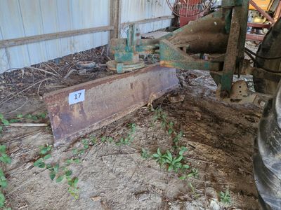 un tracteur qui est à l'arrêt dans la terre, près d'un bâtiment