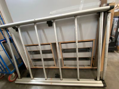 a metal railing in the middle of a room next to a wall