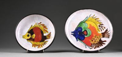 two plates with fish painted on them sitting on a table